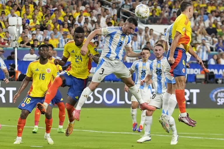 Nicolás Tagliafico y el colombiano Jhon Córdoba rematan de cabeza.