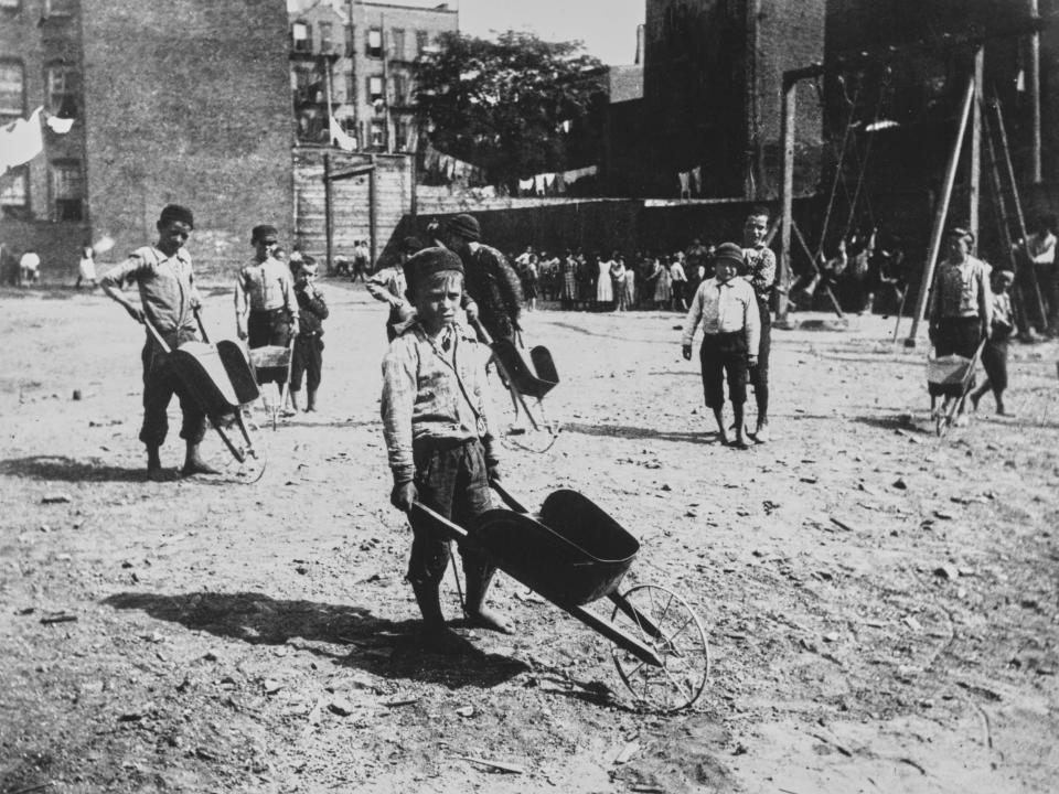 Young boys holding wheelbarrows at a playground in New York in 1890.