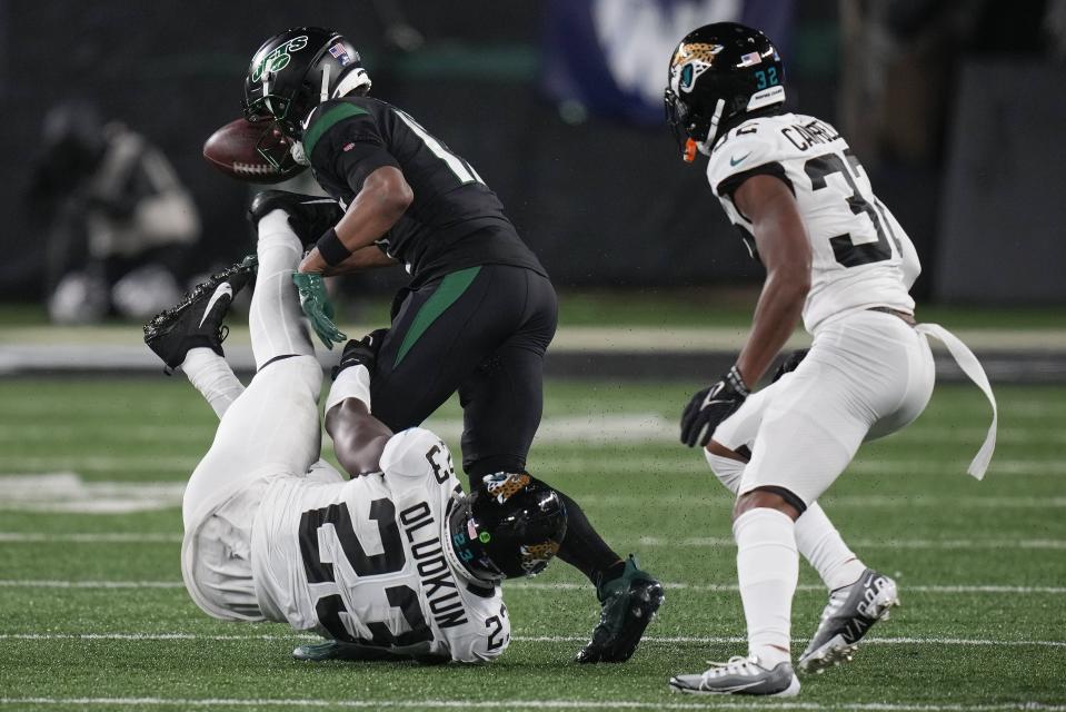 New York Jets wide receiver Garrett Wilson (17) loses the ball which was kicked away by Jacksonville Jaguars linebacker Foyesade Oluokun (23) during the fourth quarter of an NFL football game, Thursday, Dec. 22, 2022, in East Rutherford, N.J. (AP Photo/Seth Wenig)