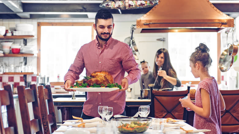 man bringing turkey to table