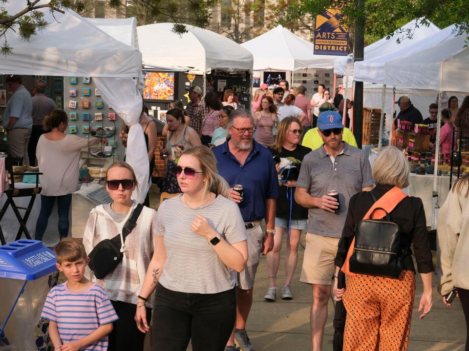 Patrons walk through the displays at the Druid City Arts Festival in Government Plaza on March 31, 2023.