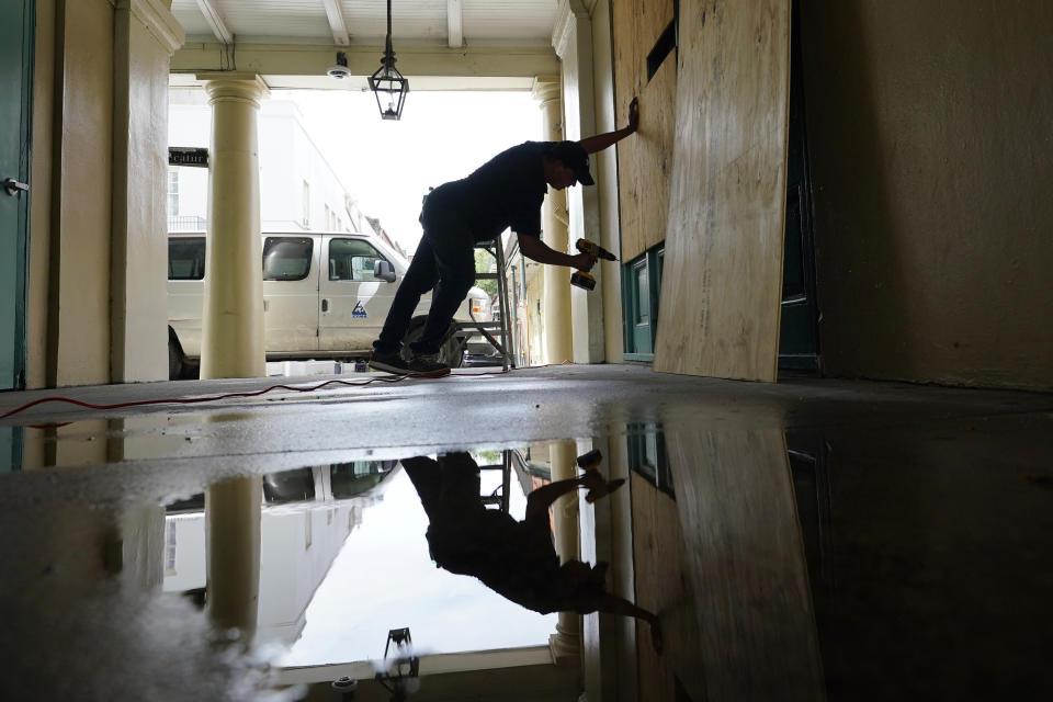 In preparation of Hurricane Ida, a worker attaches protective plywood to windows and doors of a business in the French Quarter in New Orleans, Saturday, Aug. 28, 2021. (AP Photo/Eric Gay)