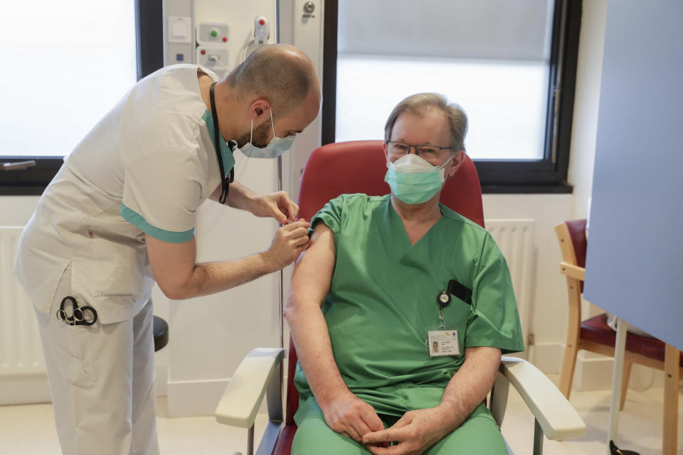 A nurse administers a Moderna COVID-19 vaccine to doctor Roger Hallemans during the national launch of the vaccination of hospital staff at the Etterbeek-Ixelles site of the Iris Sud Hospitals in Brussel​s, Monday, Jan. 18, 2021. (Stephanie Lecocq, Pool Photo via AP)