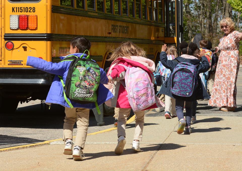 Children wearing the school uniform khaki pants board their bus after school at Uncas Elementary School in Norwich in this file photo.