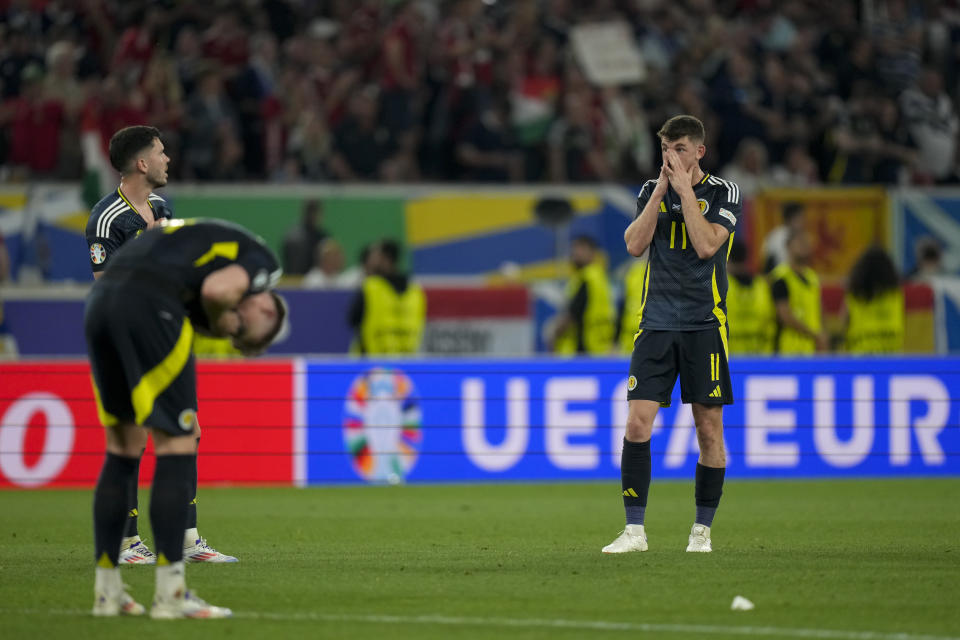 Scotland's Ryan Christie, right, covers his face at the end of a Group A match between Scotland and Hungary at the Euro 2024 soccer tournament in Stuttgart, Germany, Sunday, June 23, 2024. (AP Photo/Matthias Schrader)