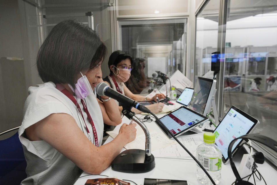 Interpreters work at the main press center during the 2020 Summer Olympics, Friday, July 30, 2021, in Tokyo, Japan. Unlike previous Olympics, all the interpretation is being done remotely with most interpreters working in booths at the main center. Their simultaneous translation can be accessed at all Olympic venues on an app. This eliminates interpreters getting tied up in traffic heading to an venue. (AP Photo/Luca Bruno)