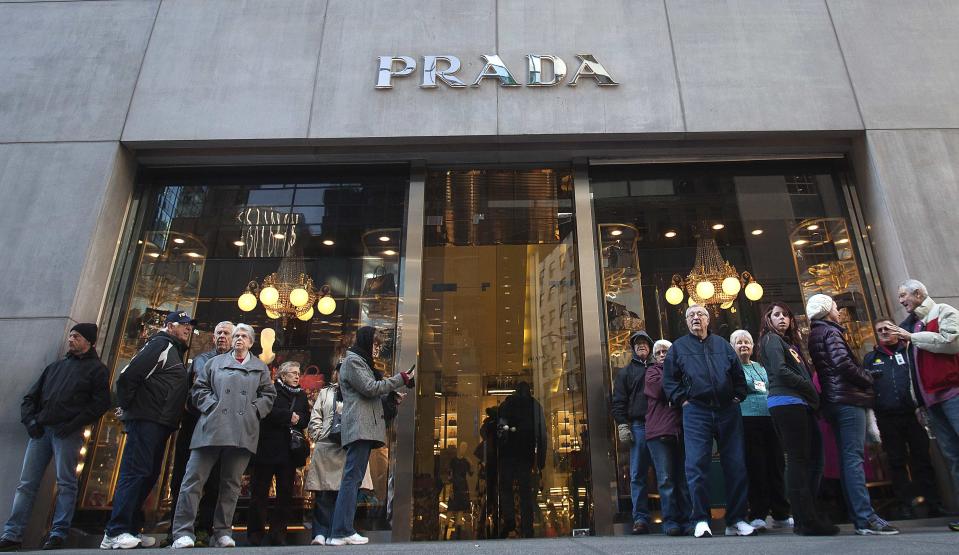 People stand outside a Prada store on 5th Ave during Black Friday Sales in New York November 29, 2013. Black Friday, the day following Thanksgiving Day holiday, has traditionally been the busiest shopping day in the United States. REUTERS/Carlo Allegri