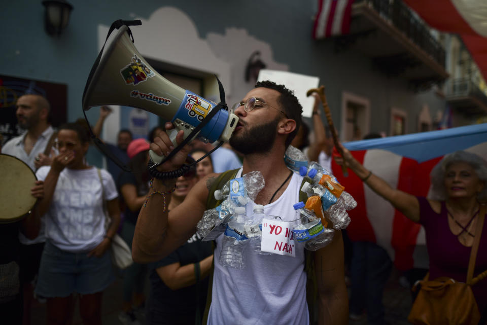 People protest outside the executive mansion known as La Fortaleza, in Old San Juan, demanding the resignation of Governor Wanda Vazquez after the discovery of an old warehouse filled with unused emergency supplies, in San Juan, Puerto Rico, Monday, Jan. 20, 2020. Anger erupted on Saturday after an online blogger posted a live video of the warehouse in the southern coastal city of Ponce filled with water bottles, cots, baby food and other basic supplies that had apparently been sitting there since Hurricane Maria battered the U.S. territory in September 2017. (AP Photo/Carlos Giusti)