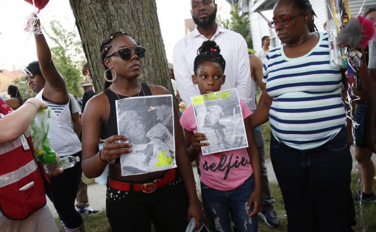 People pray for calm outside a business in Milwaukee on Aug.14, 2016. The business was burned during unrest after a police officer killed Sylville Smith on Saturday. (Photo: Jeffrey Phelps/AP)