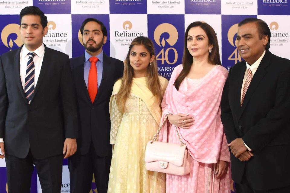 <p>INDRANIL MUKHERJEE/AFP/Getty</p> Mukesh Ambani and Nita Ambani pose with their children Akash Ambani, Anant Ambani and Isha Ambani as they arrive for Reliance Industries