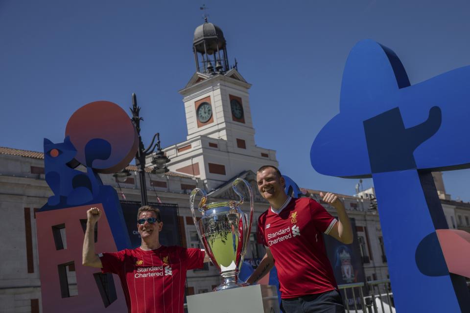 Hinchas de Liverpool posan para una foto junto al trofeo de la Liga de Campeones en la Puerta del Sol en Madrid, España, el jueves 30 de mayo de 2019. Liverpool enfrentará a Tottenham en la final de la Liga de Campeones el sábado. (AP Foto/Bernat Armangue)