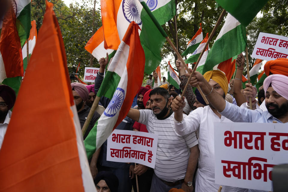 Indian Sikhs protesting against the pulling down of Indian flag from the Indian High Commission building in London shout slogans outside the British High Commission in New Delhi, India, Monday, March 20, 2023. Footage posted on social media showed a man detach the Indian flag from a balcony of the building while a crowd of people below waving bright yellow “Khalistan” banners appeared to encourage him. London’s Metropolitan Police force said a man was arrested on suspicion of violent disorder outside the diplomatic mission on Sunday afternoon. Placards in Hindi read, "India is our pride". (AP Photo/Manish Swarup)