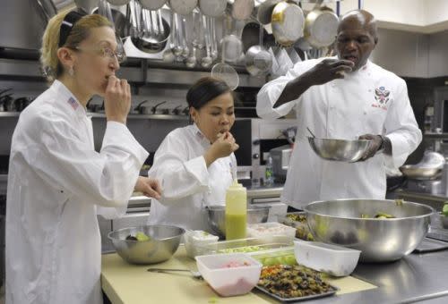 In this May 20, 2011 file photo, White House chefs, from left, Susie Morrison, executive chef Chriseta Comerford and Adam Collick, taste the salads they prepared in the kitchen of the White House in Washington. While the first lady's campaign to lower childhood obesity rates will need time to produce results, if ever, the White House is one place where her message about eating balanced meals and getting more exercise is not only resonating, but showing results, too. (AP Photo/Susan Walsh, File) 