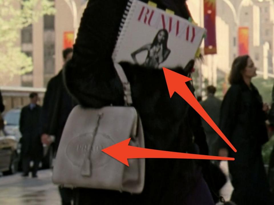 meryl streep as miranda holding a Runway book and gray prada bag in devil wears prada