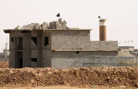 Flags of Sunni radical group Islamic State of Iraq and the Levant (ISIL) flutter on top of buildings in front of an area held by Iraqi Kurdish peshmerga (not pictured) in the town of Suleiman Bek in Salahuddin Province June 26, 2014. REUTERS/Ahmed Jadallah