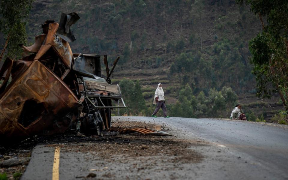 A man crosses near a destroyed truck on a road leading to the town of Abi Adi, in the Tigray region of northern Ethiopia - Ben Curtis/AP Photo