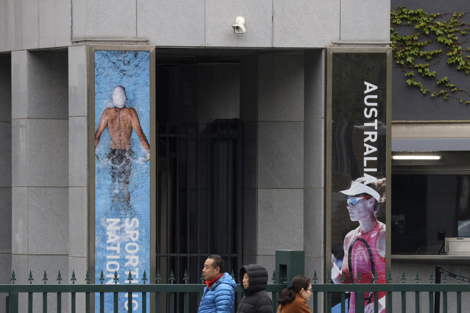 Residents walk pas the Australian embassy in Beijing, China April 9, 2019. In a notice issued June 5, 2020, China is advising its citizens not to visit Australia, citing racial discrimination and violence against Asians, in what appears to be Beijing's latest attempt to punish the country for advocating an investigation into the coronavirus pandemic. (AP Photo/Ng Han Guan)