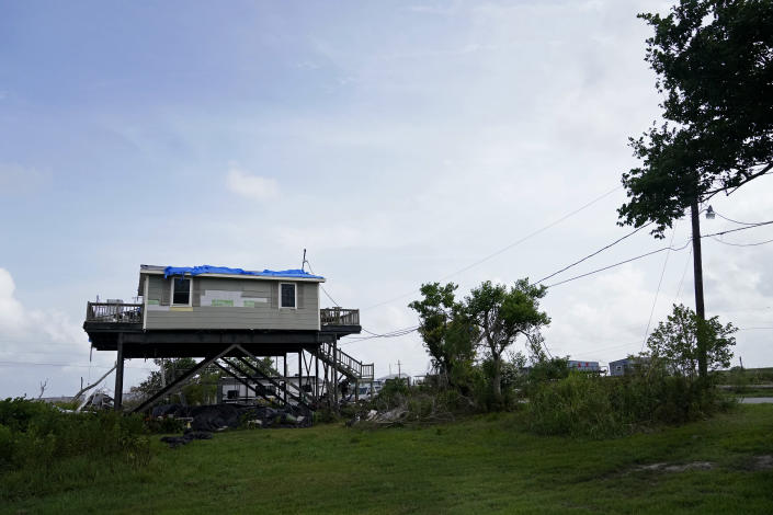 A home hat was heavily damaged by Hurricane Ida in August 2021, sits along Bayou Pointe-au-Chien, La., Tuesday, May 24, 2022. (AP Photo/Gerald Herbert)