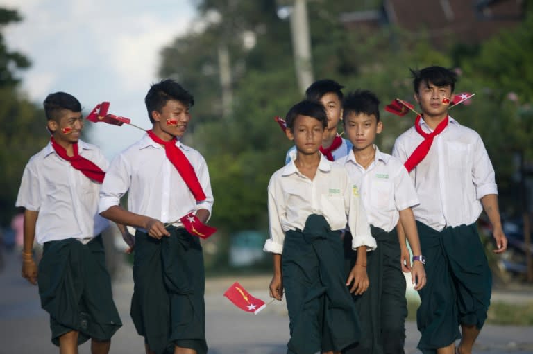 Students hold NLD flags as they leave after a speech by National League for Democracy chairperson Aung San Suu Kyi, on the outskirts of Winemaw town near the state capital Myitkyina, Kachin state, on October 2, 2015