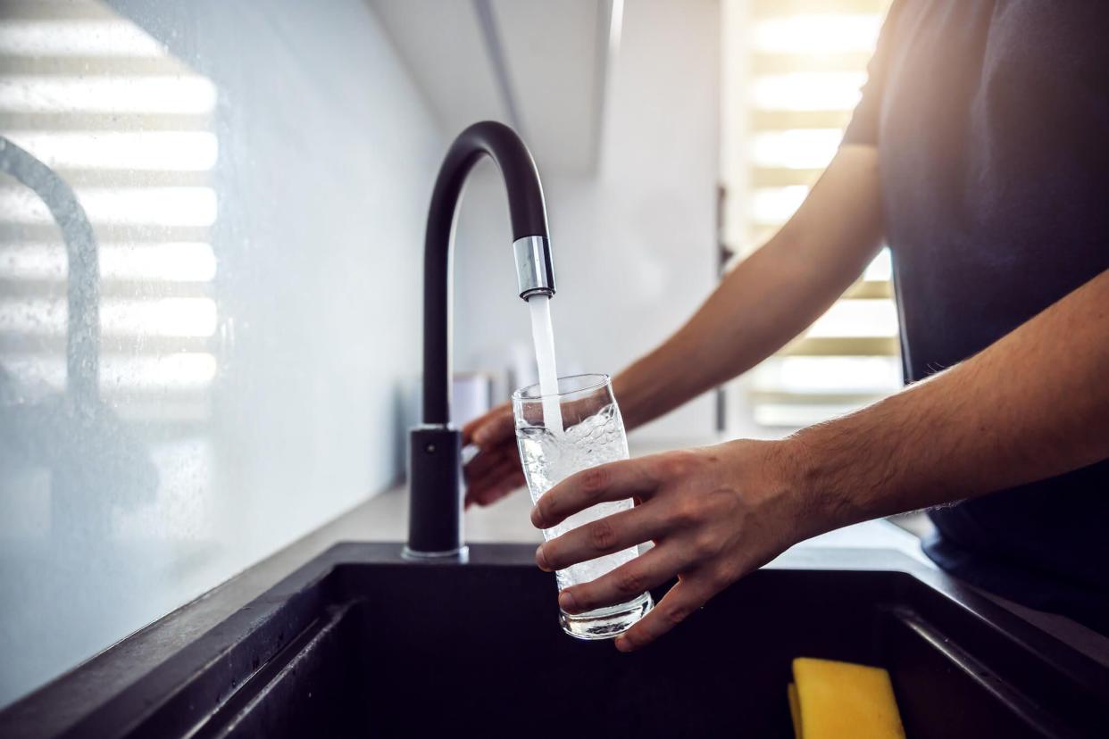 Pouring water from faucet into a cup