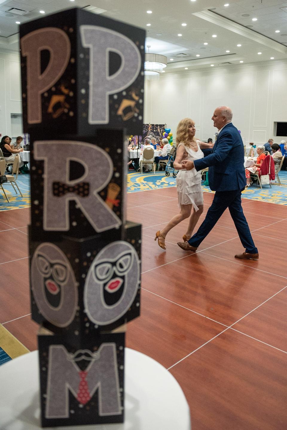 Eleanor Balsam-Gerson and her husband, Michael Gerson, dance together next to a decoration reading "Prom" during a 'Young At Heart' prom for seniors held at the the Royal Palm Beach Cultural Center on Friday, May 26, 2023, in Royal Palm Beach, Fla.