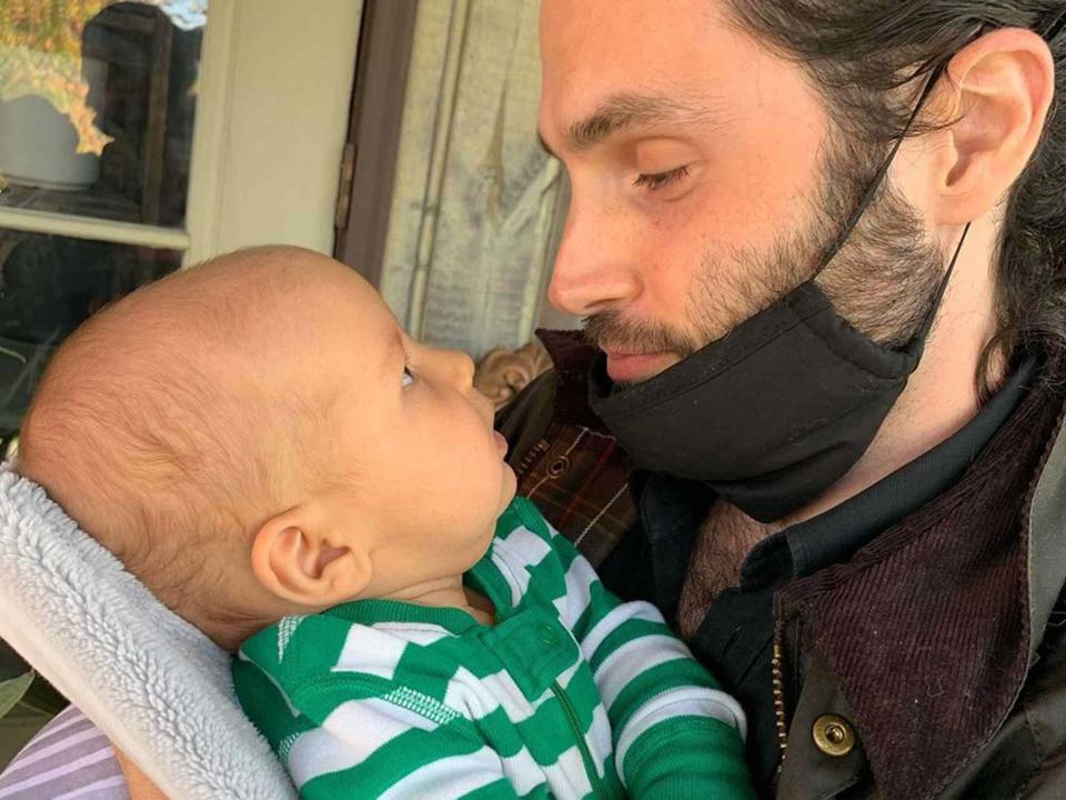 <p>Domino Kirke Instagram</p> Penn Badgley holding his son