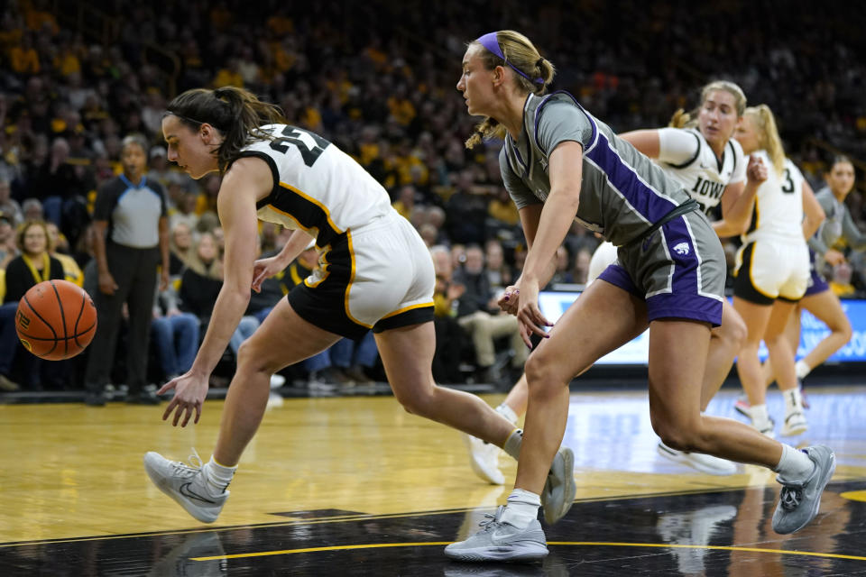 Iowa guard Caitlin Clark (22) fights for a loose ball with Kansas State guard Serena Sundell during the first half of an NCAA college basketball game, Thursday, Nov. 16, 2023, in Iowa City, Iowa. (AP Photo/Charlie Neibergall)