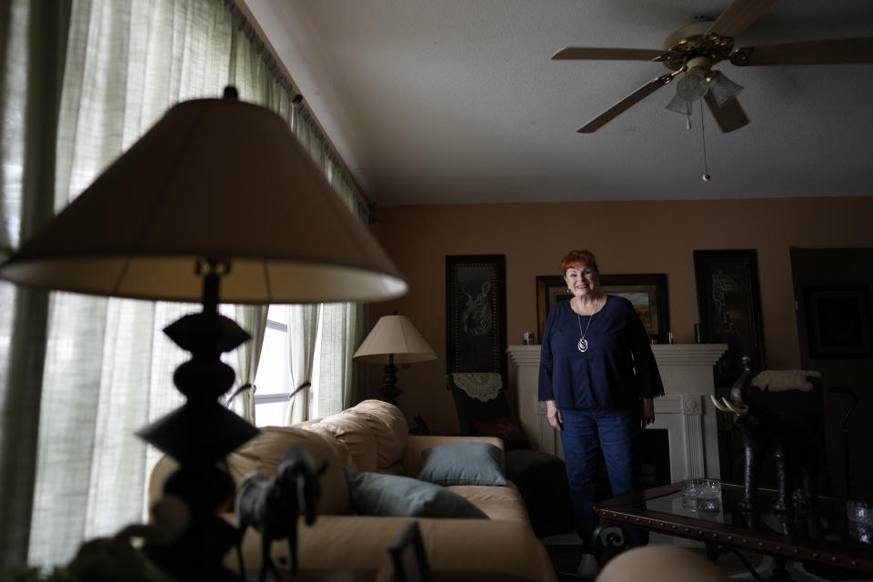 Deanna Dezern, 83, poses for a picture in her home in Tamarac, Fla., Thursday, Dec. 7, 2023. Dezern is among the first in the country to receive the robot ElliQ, whose creators, Intuition Robotics, and senior assistance officials say is the only device using artificial intelligence specifically designed to lessen the loneliness and isolation experienced by many older Americans. (AP Photo/Rebecca Blackwell)