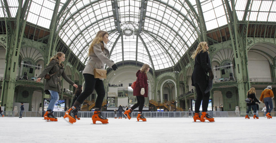 Skaters take advantage of the giant ice rink set up under the famous glass roof of the Grand Palais, in Paris Thursday Dec. 13, 2012. The Grand Palais skating rink is the largest temporary ice rink ever created in France. It will remain open until Jan. 6, 2013.(AP Photo/Remy de la Mauviniere)