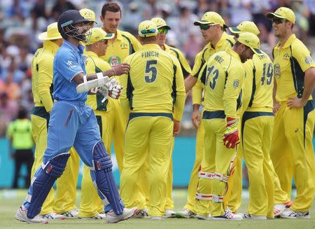 Australia's Josh Hazelwood (2nd L) celebrates with team mates as India's Shikhar Dhawan (L) walks off the ground after he was dismissed for nine runs during the One Day International cricket match in Perth January 12, 2016. REUTERS/Bill Hatto