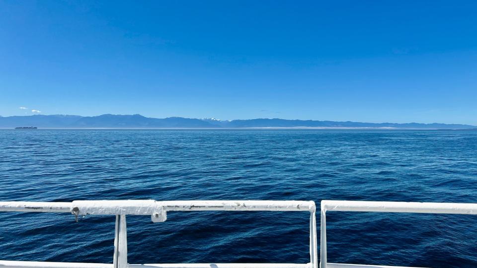 Blue waters and blue skies over a ferry railing