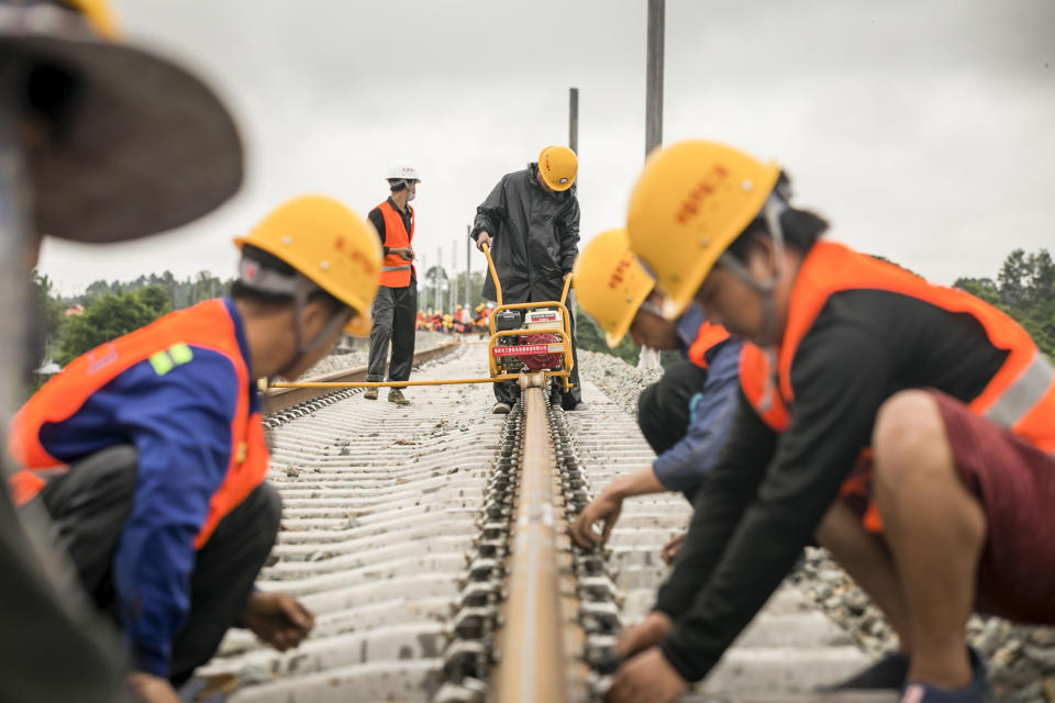 VIENTIANE, June 18, 2020 -- Workers from China Railway No.2 Engineering Group screw the welded seamless rails of the China-Laos railway in the northern suburb of Vientiane, Laos, on June 18, 2020.
  The CREC-2 has welded the first seamless rails for the China-Laos railway in the northern suburb of Lao capital Vientiane on Thursday morning. 
   The seamless rail, also known as continuous welded rail which eliminates rail joints, can improve the duration of steel rails, reduce the maintenance costs of locomotives and tracks, improve the stability and speed of trains, and enhance travel comfort. 
   The China-Laos Railway is a project of the China-proposed Belt and Road Initiative, with a joint effort, aiming to convert Laos from a landlocked country to a land-linked hub. 
   The project started in December 2016 and is scheduled to be completed and open to traffic in December 2021. (Photo by Kaikeo Saiyasane/Xinhua via Getty) (Xinhua/ via Getty Images)