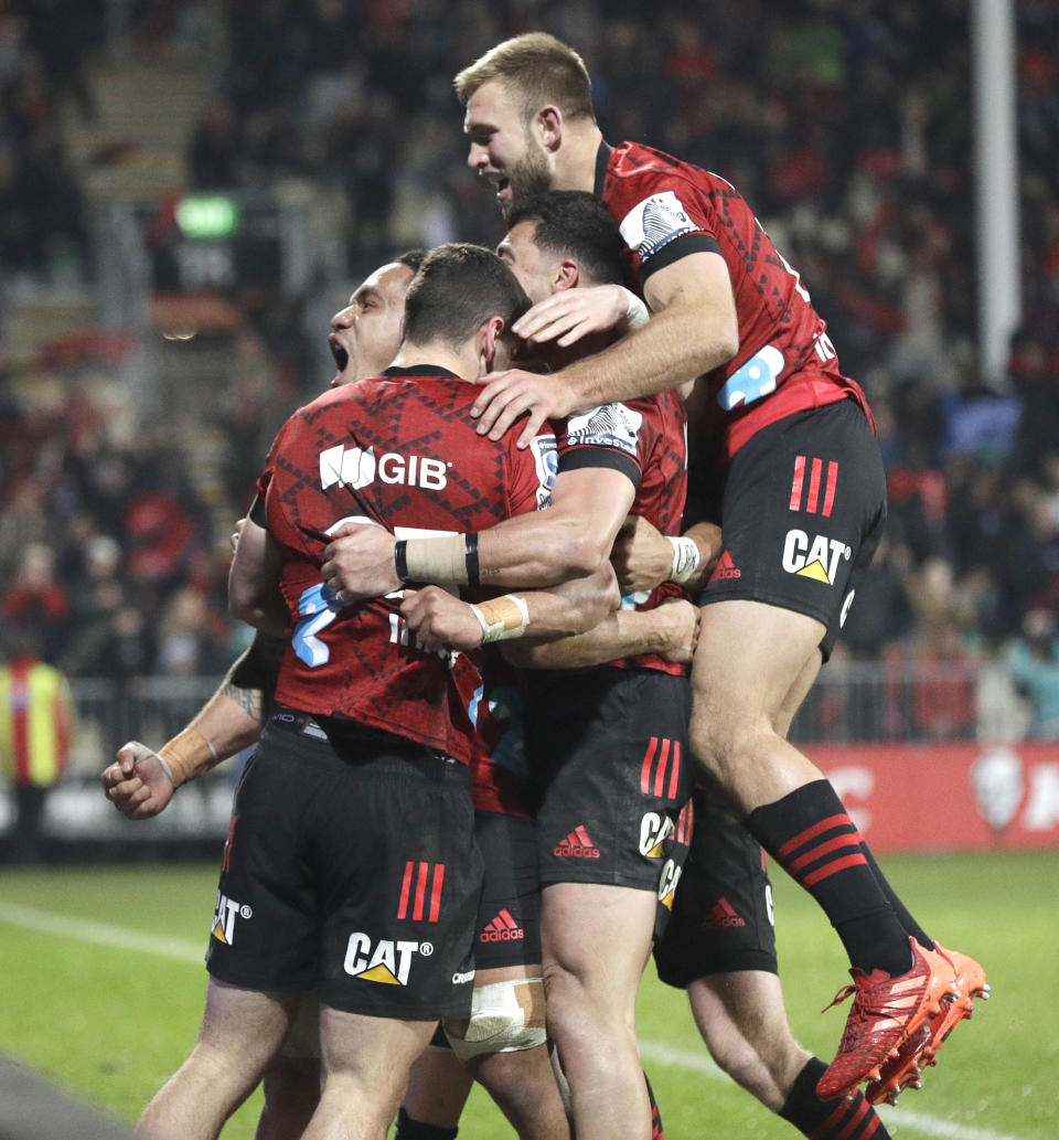 Crusaders Will Jordan, second left, is congratulated by teammates after scoring his team's match winning try during the Super Rugby Aotearoa rugby game between the Crusaders and the Blues in Christchurch, New Zealand, Saturday, July 11, 2020. (AP Photo/Mark Baker)