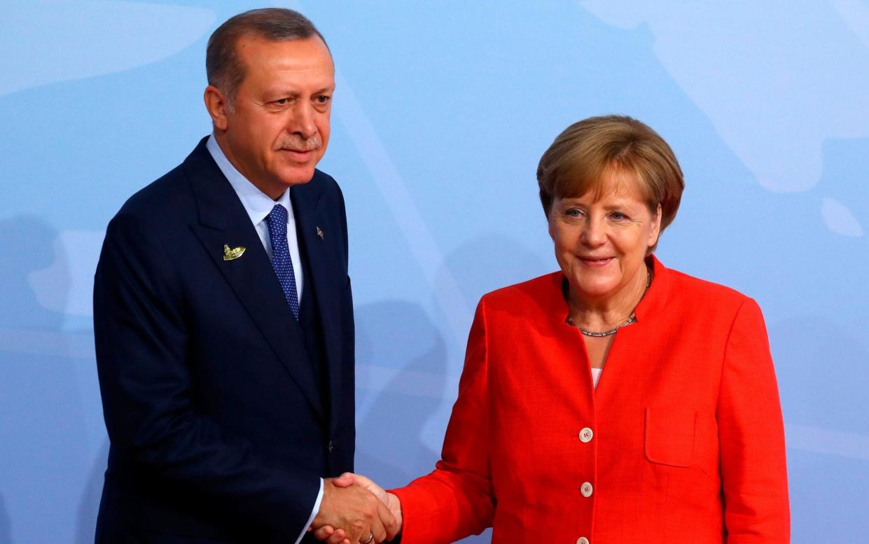 Turkish President Recep Tayyip Erdogan shakes hands with German Chancellor Angela Merkel as he arrives for the G20 leaders summit in Hamburg - REUTERS