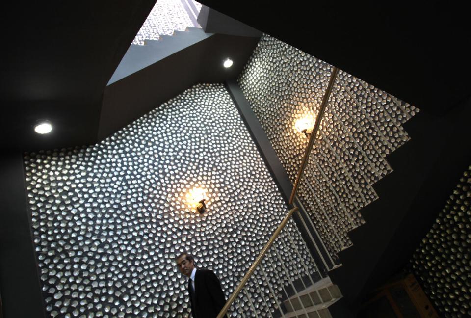 In this Wednesday, April 4, 2012 photo, Daiji Imura, Japanese pearl specialist and director of the board of RAK Pearls Holding, climbs down the staircase of a restaurant decorated with oyster shells in Ras al-Khaimah, United Arab Emirates. Long before the discovery of oil transformed the Gulf, the region's pearl divers were a mainstay of the economy. Their way of life, however, also was changed forever after Japanese researchers learned how to grow cultured pearls in 1930s. Now a collaboration between pearl traders in Japan and the United Arab Emirates had brought oyster farming to the UAE for the first time. (AP Photo/Kamran Jebreili)