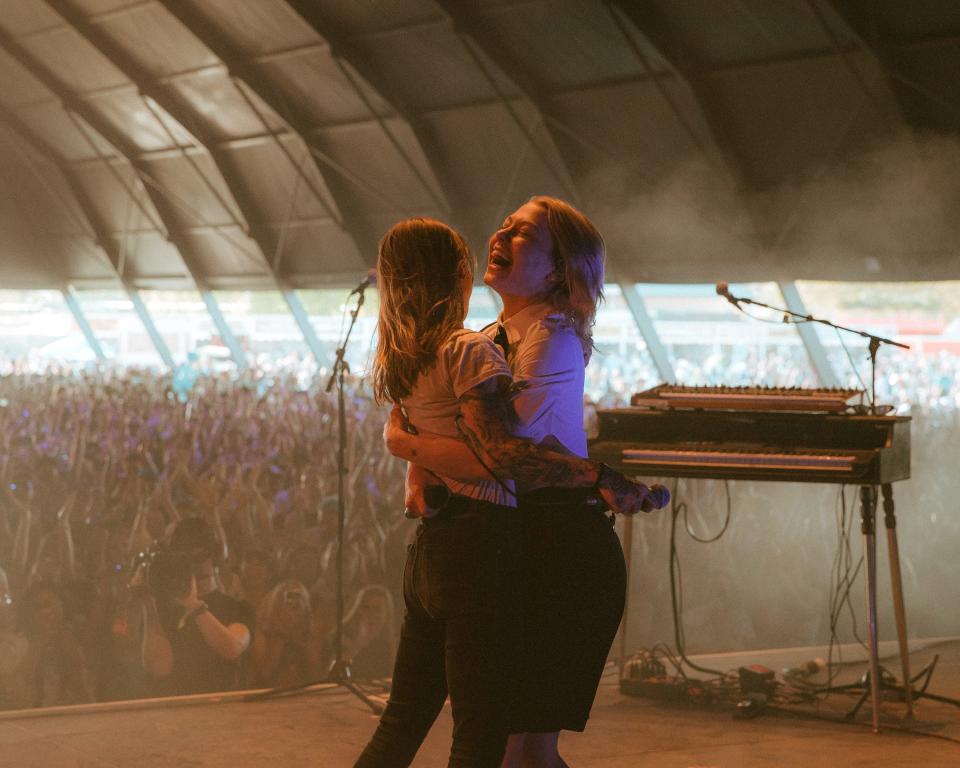 Phoebe Bridgers (right) embraces boygenius bandmate Julien Baker shortly after they both came out as surprise guests during MUNA's Coachella set on Friday, April 14 at the Empire Polo Club in Indio, Calif.