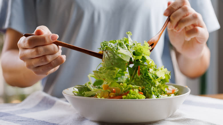 Mixing salad ingredients in a bowl