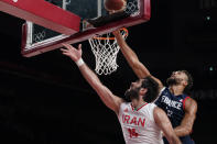 Iran's Mohammadsamad Nik Khahbahrami (14), left, is fouled by France's Rudy Gobert (27) during men's basketball preliminary round game at the 2020 Summer Olympics, Saturday, July 31, 2021, in Saitama, Japan. (AP Photo/Charlie Neibergall)