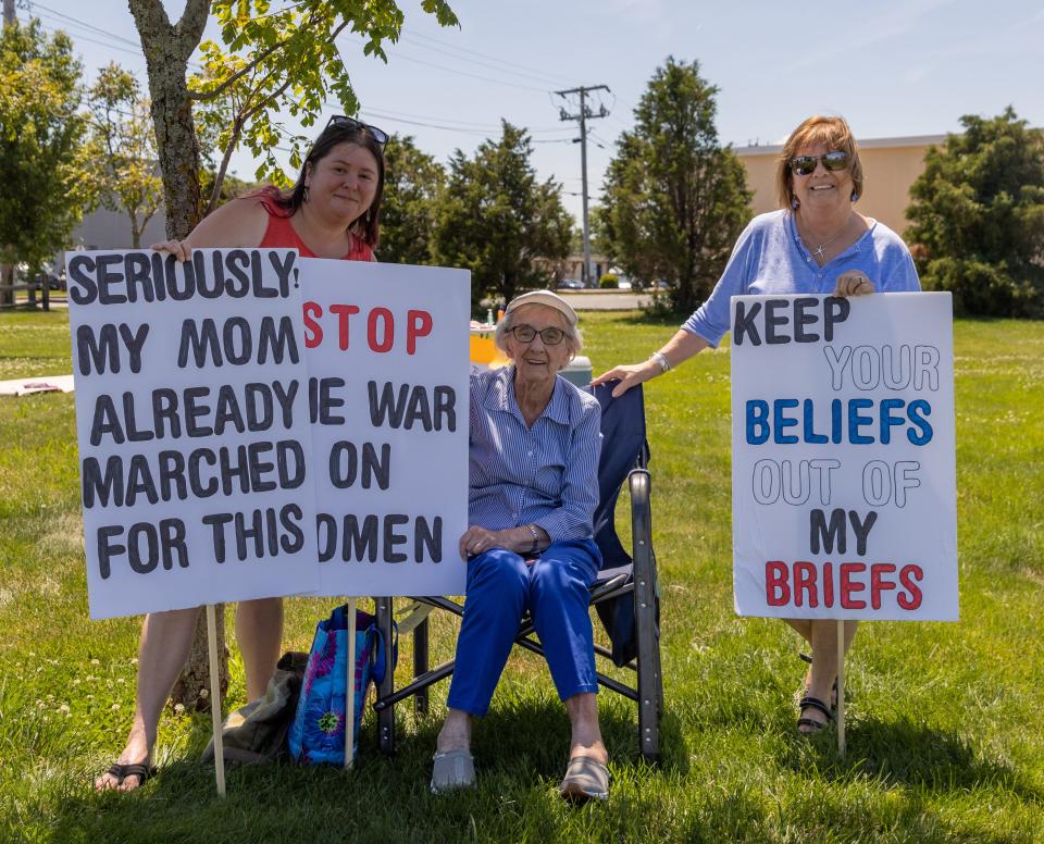 Three generations of women protest on Saturday at the Hyannis rotary . Ashley Granger, left, is the granddaughter of Tillie Laverdiene, middle, and daughter of Linda Gregoire, right.