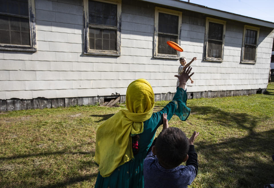 Volunteer Sandra Hoeser plays frisbee with Afghan refugees at the Ft. McCoy U.S. Army base on Thursday, Sept. 30, 2021 in Ft. McCoy, Wis. The fort is one of eight military installations across the country that are temporarily housing the tens of thousands of Afghans who were forced to flee their homeland in August after the U.S. withdrew its forces from Afghanistan and the Taliban took control. (Barbara Davidson/Pool Photo via AP)