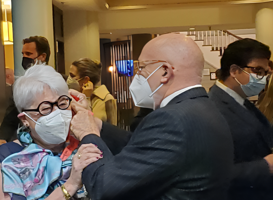 In this March 2022 file photo, Dr. Geoffrey Clark helps his wife, former state Sen. Martha Fuller Clark, both of Portsmouth, put on her facemask at an 80th birthday celebration for Fuller Clark at the Sheraton in Portsmouth. Dr. Clark died on Saturday, Jan. 7, 2023 at the age of 84 years old.