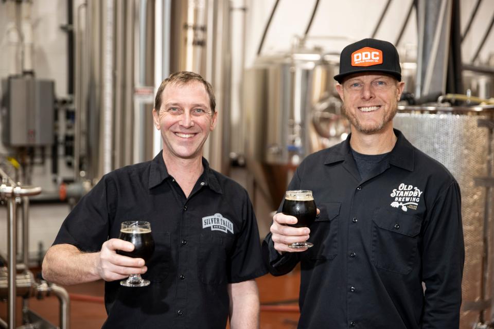 El copropietario y cervecero de Silver Falls Brewery, Andrew Fox, y el cervecero casero Ryan Holt sostienen la Javine Baltic Porter que elaboraron en colaboración en Silver Falls Brewery.