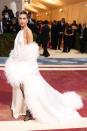 <p>Bieber arrived solo for this year's Met Gala, in a bridal-inspired white, feather-trimmed gown by Saint Laurent.</p>