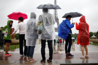 Tourists stroll on the Trocadero square, in front of the Eiffel Tower during a rainy day in Paris, France, May 30, 2016. REUTERS/Charles Platiau