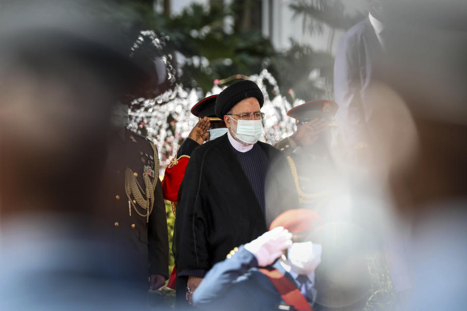 Iran's President Ebrahim Raisi, center, inspects the honor guard after arriving at State House in Entebbe, Uganda Wednesday, July 12, 2023. Iran's president has begun a rare visit to Africa as the country, which is under heavy U.S. economic sanctions, seeks to deepen partnerships around the world. (AP Photo/Hajarah Nalwadda)