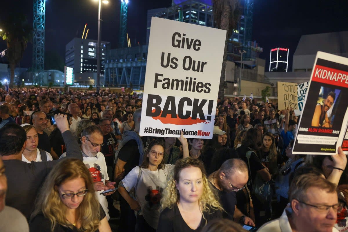 Protesters lift placards as they rally to demand the release of Israelis held hostage in Gaza (AFP via Getty Images)