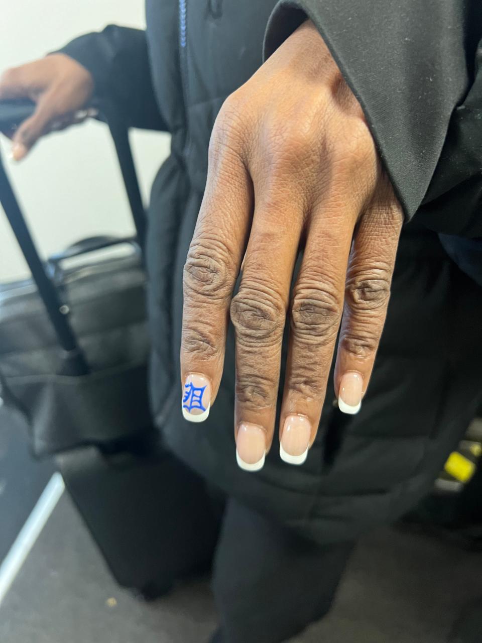 Cherlyn Rupert shows off her Detroit-themed nails before boarding a plane at Detroit Metropolitan Airport. The Detroit Lions season ticket holder plans to attend the NFC Championship game against the San Francisco 49ers.