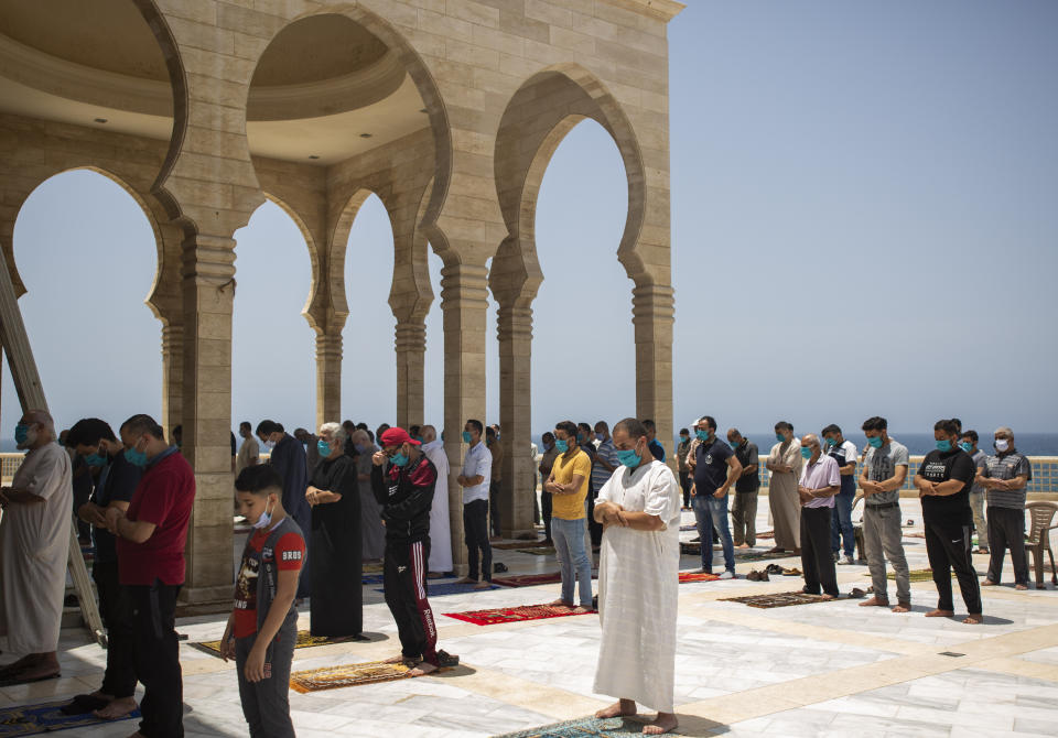 Palestinians wearing face masks attend the last Friday noon Prayer of the holy month of Ramadan, in a mosque in Gaza City, Friday, May. 22, 2020. After nearly two months of closure due to the coronavirus, Gaza's Hamas rulers decided to partially reopen mosques for the Friday noon prayer. (AP Photo/Khalil Hamra)