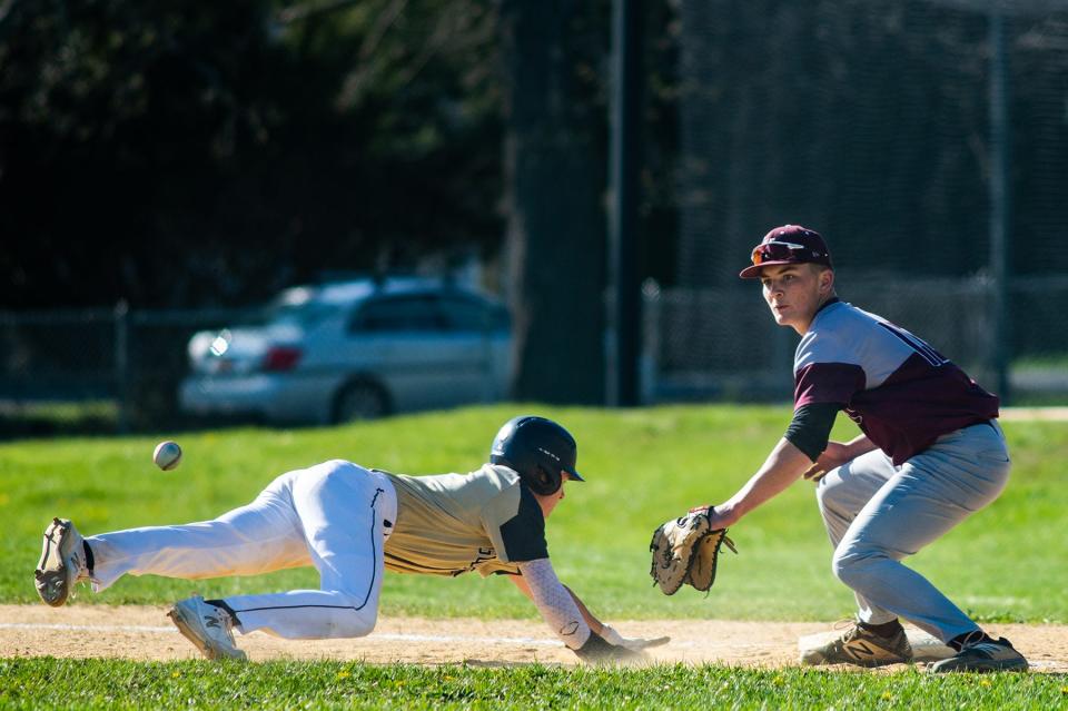 Newburgh's Nick Schmidt slides into first base as Kingston's Jake Bonesteel waits for the ball during the Section 9 class AA boys baseball game in Newburgh, NY on Thursday, April 28, 2022. Kingston defeated Newburgh. KELLY MARSH/FOR THE TIMES HERALD-RECORD