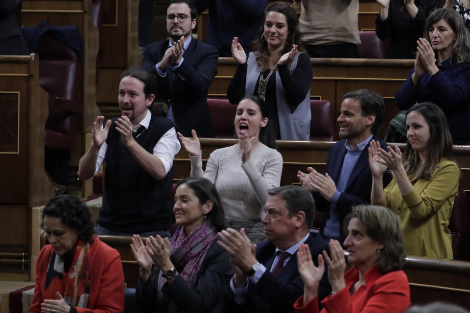 Podemos leader Pablo Iglesias, centre left applauds together with deputies from Podemos and the Spanish socialist party at the Spanish Parliament in Madrid, Spain, Sunday, Jan. 5, 2020. Spain's interim Prime Minister Pedro Sanchez is facing the first of two opportunities Sunday to win the endorsement of the Spanish Parliament to form a left-wing coalition government. It would be Spain's first coalition government since the return of democracy following the death of dictator Francisco Franco in 1975. (AP Photo/Manu Fernandez)
